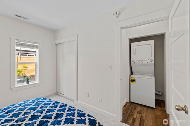 1040 S Director St Unit A, Seattle, WA 98108 - bedroom with estacked washer and dryer, a closet, and wood finished floors