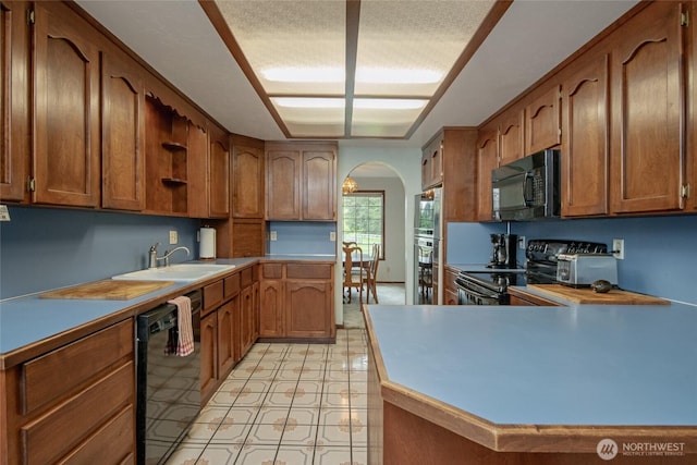 213 Monte Elma Rd, Montesano, WA 98563 - kitchen featuring black appliances, arched walkways, open shelves, a peninsula, and brown cabinetry