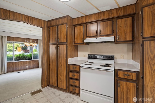 4915 Samish Unit 66, Bellingham, WA 98229 - kitchen with white electric range, under cabinet range hood, a chandelier, light countertops, and wooden walls