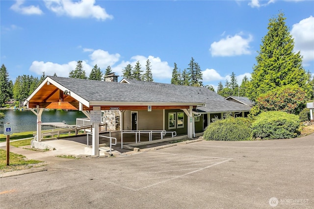21628 SE 271st St, Maple Valley, WA 98038 - view of front of home featuring a chimney, a water view, roof with shingles, uncovered parking, and covered porch