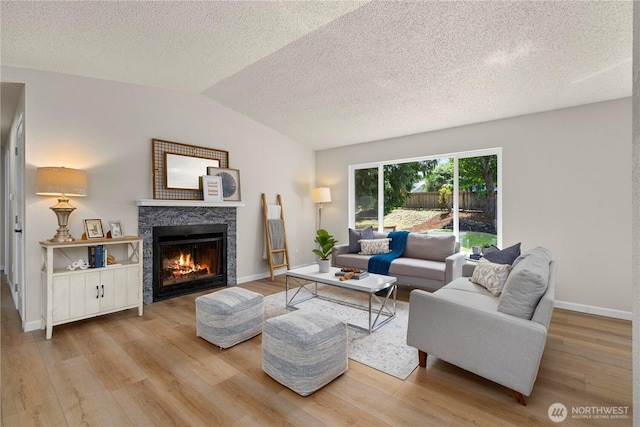 5201 S 298th Ct, Auburn, WA 98001 - living area with wood finished floors, a warm lit fireplace, a textured ceiling, and lofted ceiling