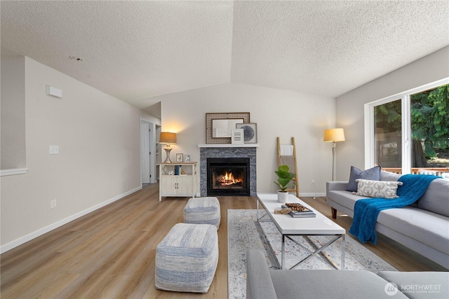 5201 S 298th Ct, Auburn, WA 98001 - living area featuring light wood-style floors, a lit fireplace, a textured ceiling, and lofted ceiling