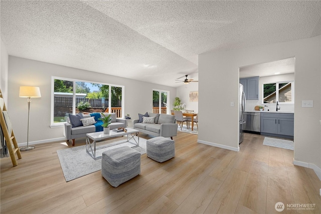 5201 S 298th Ct, Auburn, WA 98001 - living room featuring light wood-style floors, ceiling fan, healthy amount of natural light, and a textured ceiling