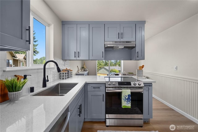 5201 S 298th Ct, Auburn, WA 98001 - kitchen with stainless steel appliances, under cabinet range hood, gray cabinets, wood finished floors, and backsplash