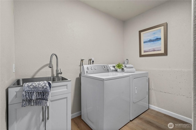 5201 S 298th Ct, Auburn, WA 98001 - washroom featuring separate washer and dryer, light wood-type flooring, and cabinet space