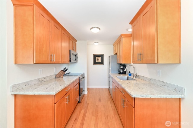 3722 27th Pl W Unit 301, Seattle, WA 98199 - kitchen with stainless steel appliances, light wood-type flooring, and light stone counters