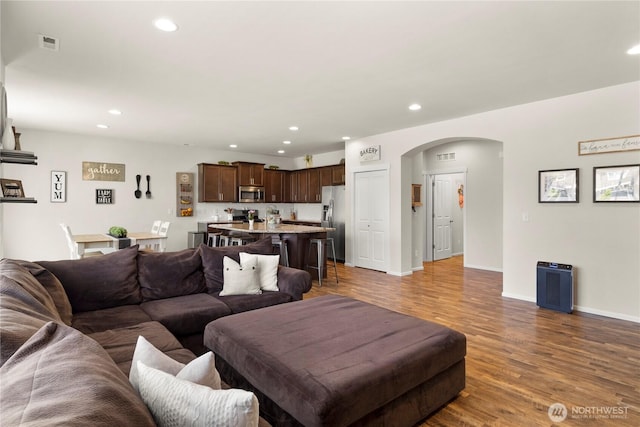 902 Van Ogle Ln NW, Orting, WA 98360 - living room featuring arched walkways, wood finished floors, and recessed lighting
