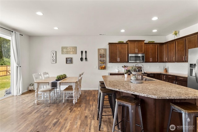 902 Van Ogle Ln NW, Orting, WA 98360 - kitchen featuring stainless steel appliances, a breakfast bar, tasteful backsplash, dark wood-style flooring, and recessed lighting