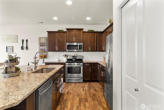 902 Van Ogle Ln NW, Orting, WA 98360 - kitchen with appliances with stainless steel finishes, dark wood finished floors, light stone counters, decorative backsplash, and recessed lighting