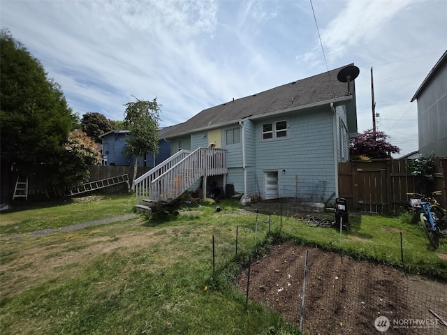 2719 Pacific Ave, Hoquiam, WA 98550 - back of house featuring a fenced backyard, stairs, a garden, and a shingled roof