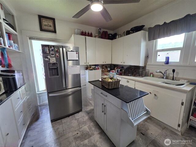 2719 Pacific Ave, Hoquiam, WA 98550 - kitchen with stainless steel refrigerator with ice dispenser, white cabinets, a center island, and ceiling fan