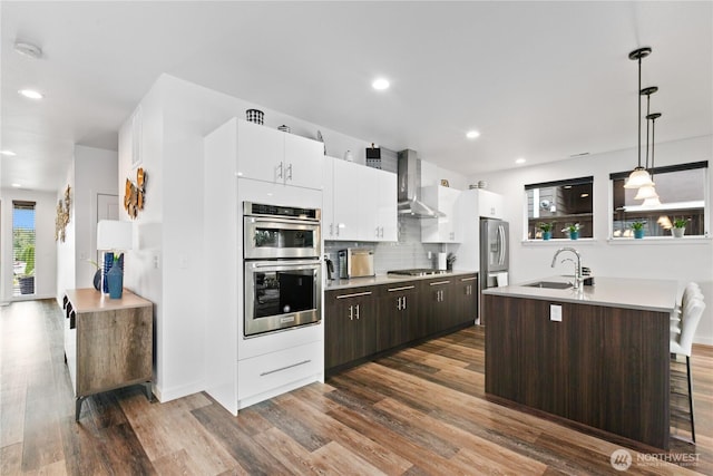 2511 124th Pl SE, Everett, WA 98208 - kitchen with stainless steel appliances, wall chimney range hood, dark wood-style flooring, light countertops, and recessed lighting