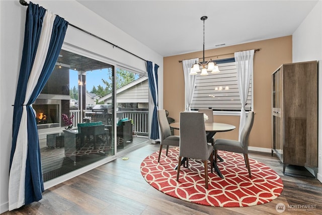 2511 124th Pl SE, Everett, WA 98208 - dining space featuring a chandelier, wood finished floors, and a lit fireplace