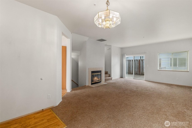 6317 Barstow Ln SE Unit 8, Lacey, WA 98513 - unfurnished living room with a tiled fireplace, a chandelier, and carpet