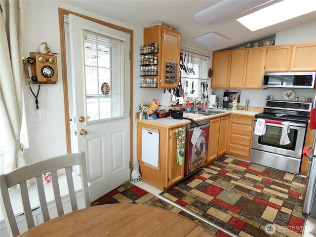 1200 Lincoln St Unit 154, Bellingham, WA 98229 - kitchen featuring appliances with stainless steel finishes, light countertops, plenty of natural light, vaulted ceiling, and light brown cabinets