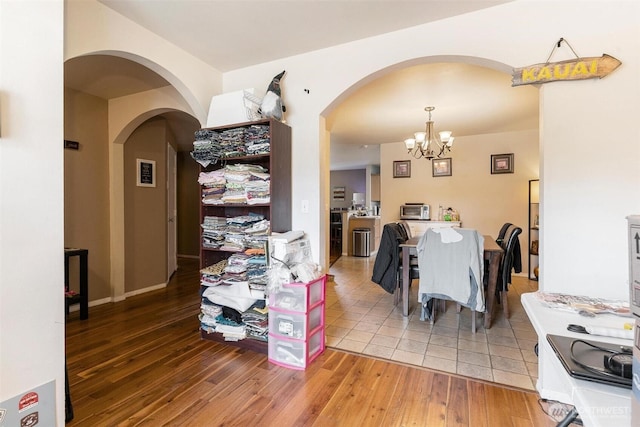 6725 159th St E, Puyallup, WA 98375 - dining room with a chandelier, arched walkways, and light wood-style floors