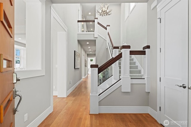 8246 W Mercer Way, Mercer Island, WA 98040 - entryway with stairway, wood finished floors, a towering ceiling, recessed lighting, and a chandelier