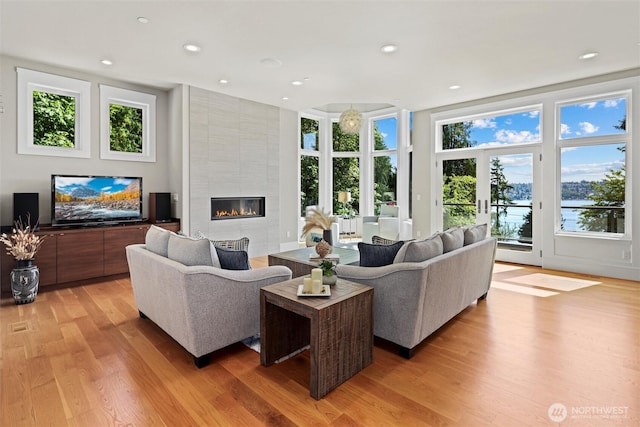 8246 W Mercer Way, Mercer Island, WA 98040 - living area featuring light wood finished floors, a fireplace, recessed lighting, and a water view