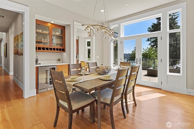 8246 W Mercer Way, Mercer Island, WA 98040 - dining area with beverage cooler, light wood-type flooring, french doors, bar area, and recessed lighting