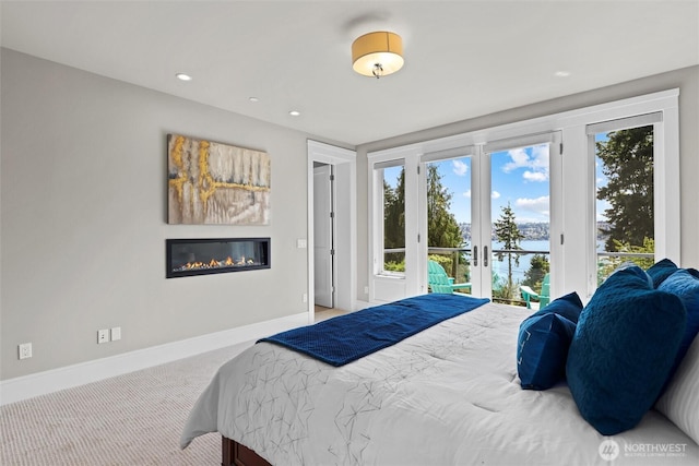 8246 W Mercer Way, Mercer Island, WA 98040 - bedroom with french doors, a glass covered fireplace, access to exterior, multiple windows, and recessed lighting