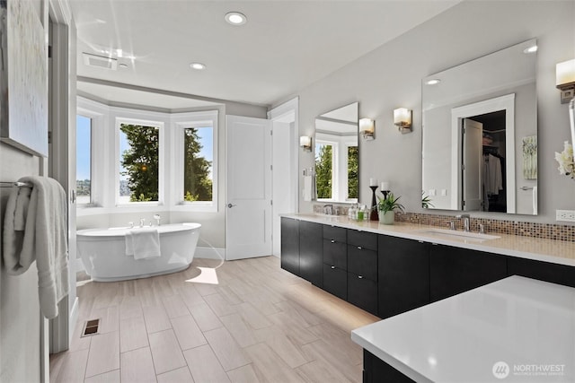 8246 W Mercer Way, Mercer Island, WA 98040 - full bathroom featuring a soaking tub, double vanity, recessed lighting, tasteful backsplash, and a spacious closet