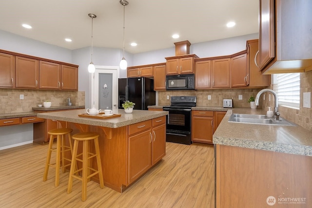 2117 197th Street Ct E, Spanaway, WA 98387 - kitchen with black appliances, light wood finished floors, decorative backsplash, a center island, and a kitchen bar