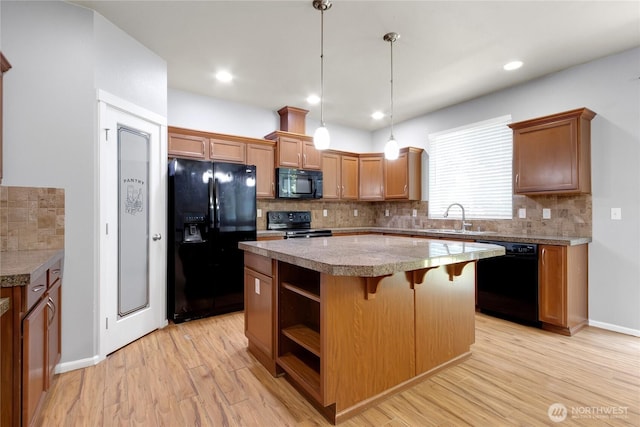 2117 197th Street Ct E, Spanaway, WA 98387 - kitchen featuring black appliances, tasteful backsplash, a center island, light wood-type flooring, and a kitchen breakfast bar