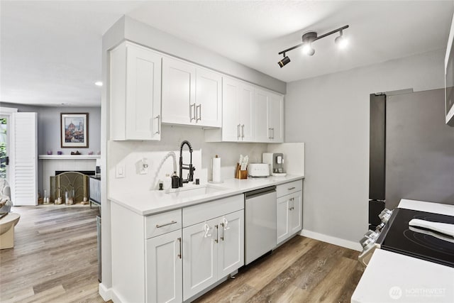916 3rd Ave Unit A104, Kirkland, WA 98033 - kitchen featuring stainless steel appliances, white cabinets, light countertops, and light wood finished floors