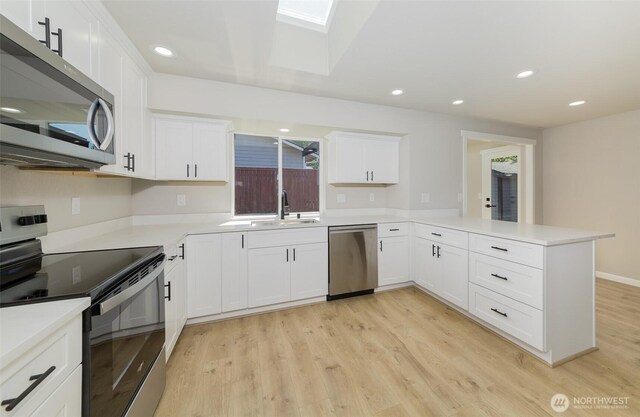 9621 1st Ave SE, Everett, WA 98208 - kitchen with stainless steel appliances, a peninsula, light wood-type flooring, white cabinets, and recessed lighting