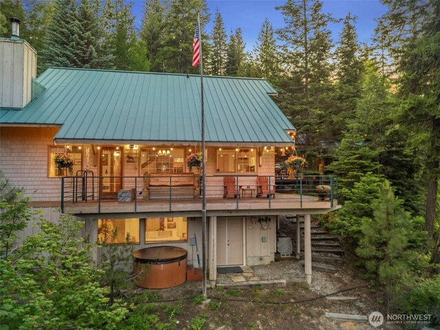 2290 Riffle Dr, Leavenworth, WA 98826 - back of house with stairs, a metal roof, a hot tub, a chimney, and a standing seam roof