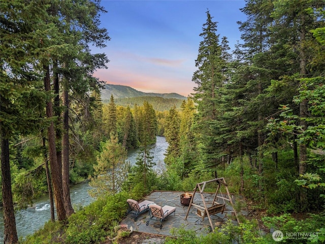 2290 Riffle Dr, Leavenworth, WA 98826 - view of yard featuring a fire pit, a wooded view, a patio area, and a water and mountain view