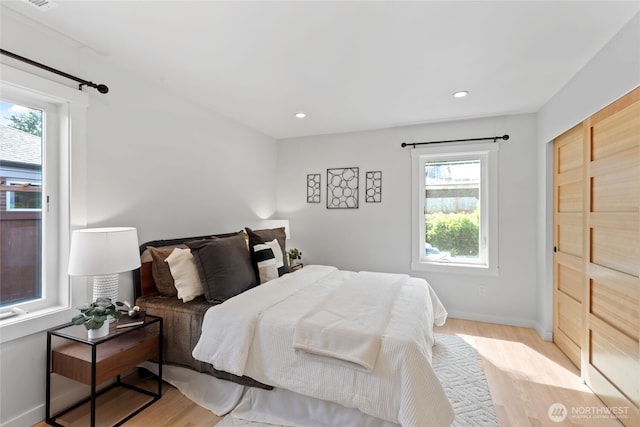 8315 24th Ave NW, Seattle, WA 98117 - bedroom featuring multiple windows, light wood-style floors, recessed lighting, and a barn door