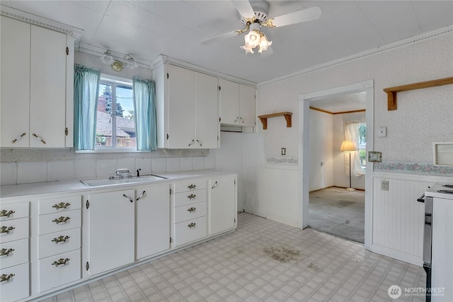 2209 S Talbot Rd, Renton, WA 98055 - kitchen featuring white range with electric cooktop, light countertops, a wainscoted wall, light floors, and crown molding