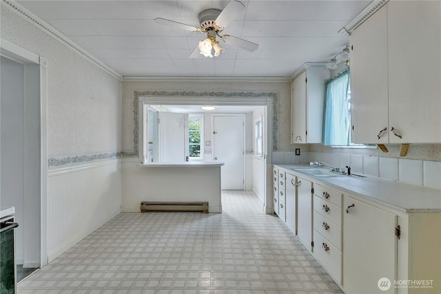 2209 S Talbot Rd, Renton, WA 98055 - kitchen with light countertops, a baseboard radiator, light floors, a wainscoted wall, and ceiling fan