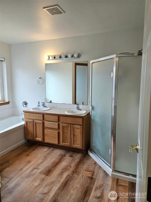 741 G St SW, Tumwater, WA 98512 - full bathroom featuring a shower stall, double vanity, a garden tub, and wood finished floors
