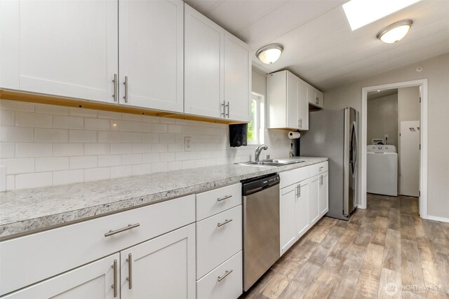 3010 248th Street Ct E, Spanaway, WA 98387 - kitchen with washer / dryer, stainless steel appliances, white cabinets, and backsplash