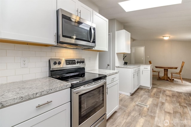 3010 248th Street Ct E, Spanaway, WA 98387 - kitchen with stainless steel appliances, light wood-type flooring, white cabinets, and decorative backsplash
