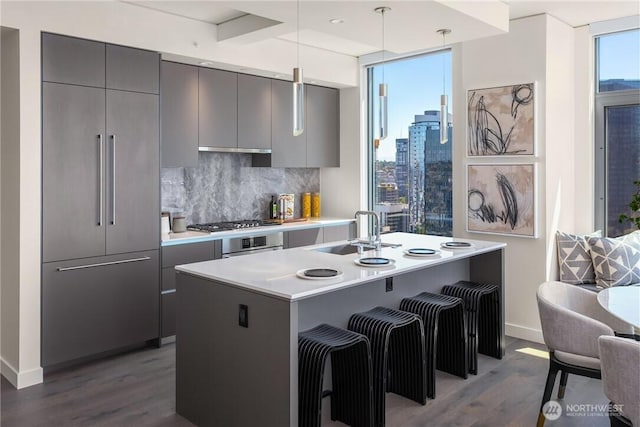 2510 6th Ave Unit 1704, Seattle, WA 98121 - kitchen featuring modern cabinets, dark wood-style floors, paneled built in refrigerator, and tasteful backsplash