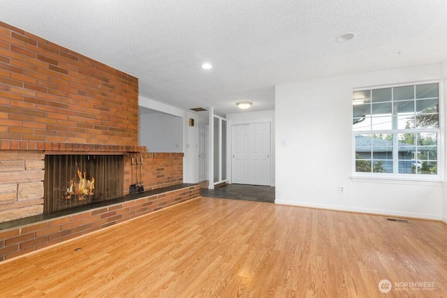 731 Maplewood Ave, Kent, WA 98030 - unfurnished living room with a textured ceiling, wood finished floors, a fireplace, and recessed lighting