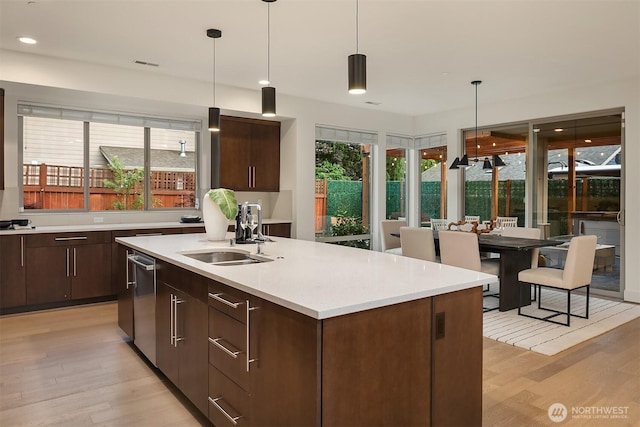 10637 128th Ave NE, Kirkland, WA 98033 - kitchen with light wood-style flooring, light countertops, dark brown cabinets, a center island with sink, and modern cabinets