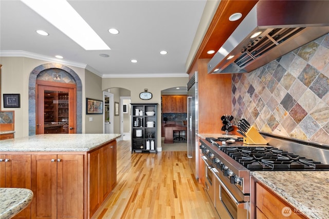 60 Marigold Dr, Bellingham, WA 98229 - kitchen featuring range hood, premium appliances, arched walkways, brown cabinets, and recessed lighting