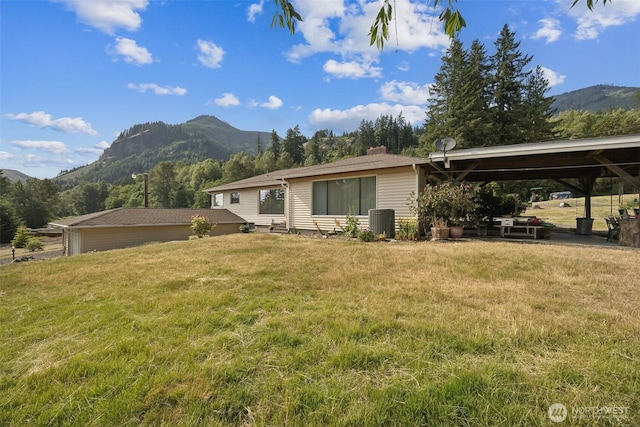 107 Peters Crk, Randle, WA 98377 - rear view of property with a mountain view, a chimney, and a yard