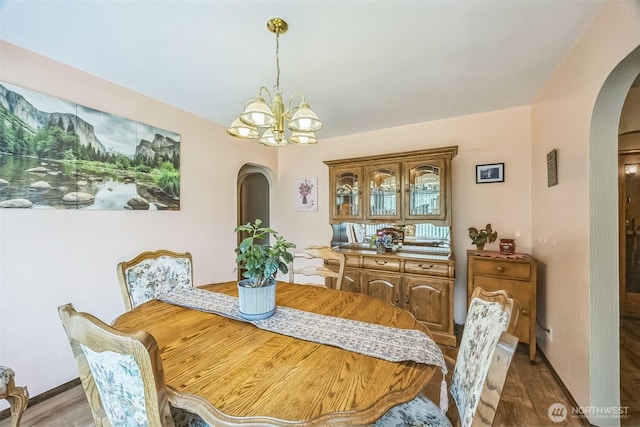 107 Peters Crk, Randle, WA 98377 - dining space featuring arched walkways, wood finished floors, and a chandelier