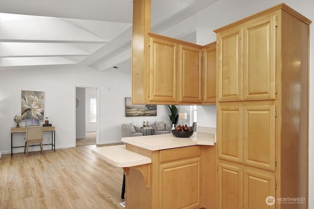 24027 222nd Pl SE Unit 88, Maple Valley, WA 98038 - kitchen with a peninsula, light countertops, light wood finished floors, a breakfast bar, and light brown cabinets
