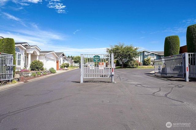 24027 222nd Pl SE Unit 88, Maple Valley, WA 98038 - view of asphalt road with a gated entry, a residential view, and curbs
