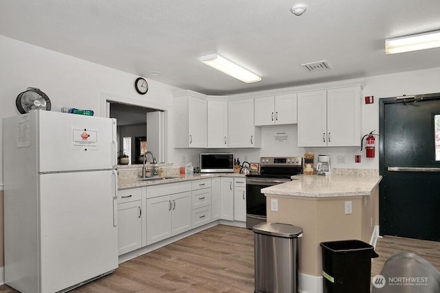 24027 222nd Pl SE Unit 88, Maple Valley, WA 98038 - kitchen featuring freestanding refrigerator, electric range oven, light wood-type flooring, and white cabinets