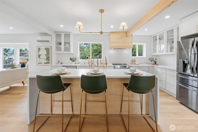 4658 N Defiance St, Tacoma, WA 98407 - kitchen featuring stainless steel appliances, a wall mounted AC, light countertops, custom exhaust hood, and a center island