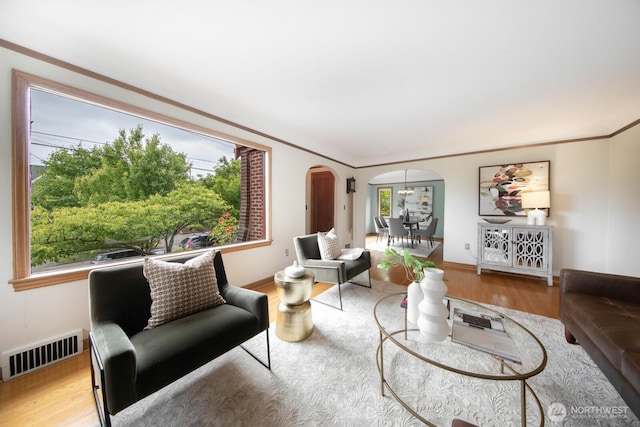 7310 10th Ave NW, Seattle, WA 98117 - living area featuring arched walkways, healthy amount of natural light, wood finished floors, and crown molding