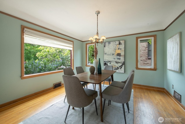 7310 10th Ave NW, Seattle, WA 98117 - dining room featuring ornamental molding, light wood-style floors, and a chandelier
