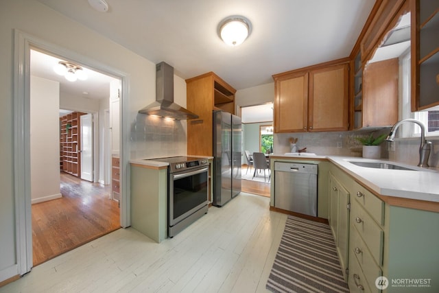 7310 10th Ave NW, Seattle, WA 98117 - kitchen featuring wall chimney range hood, stainless steel appliances, light countertops, and light wood-type flooring